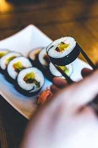 Man eating Traditional Korean Gimbap rice rolls with chopsticks