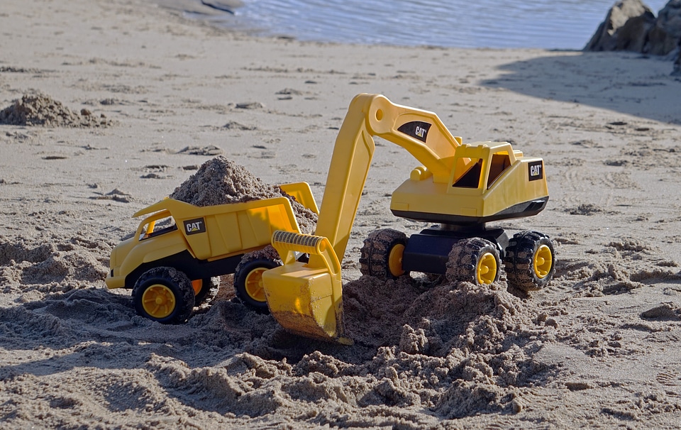 Excavator and Tipper Toys on the Beach Working with Sand