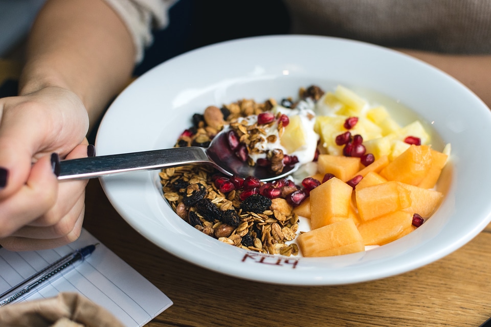 Eating granola with fresh fruits
