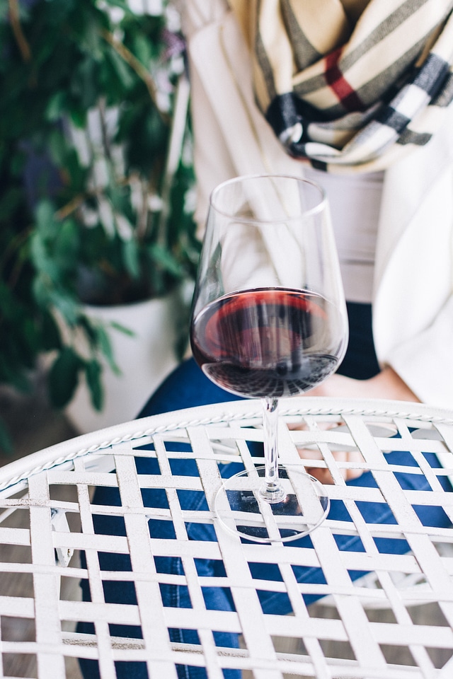 Lady with a glass of red wine in a wine shop