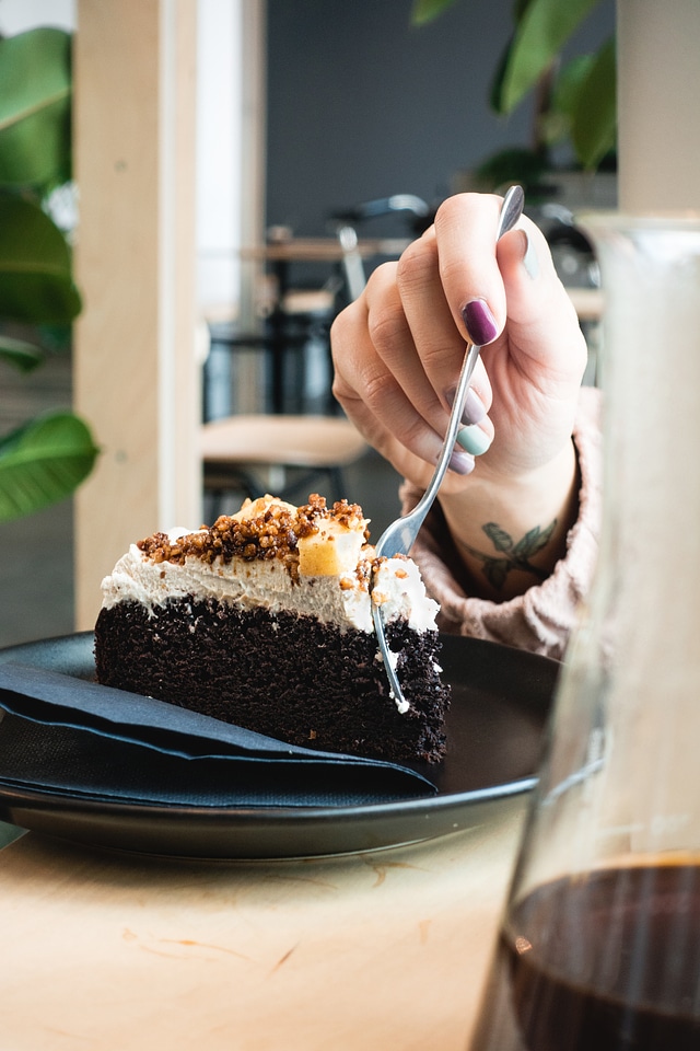 Girl eating delicious chocolate cake with apples
