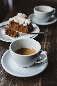 Close up of espresso coffee with cake behind