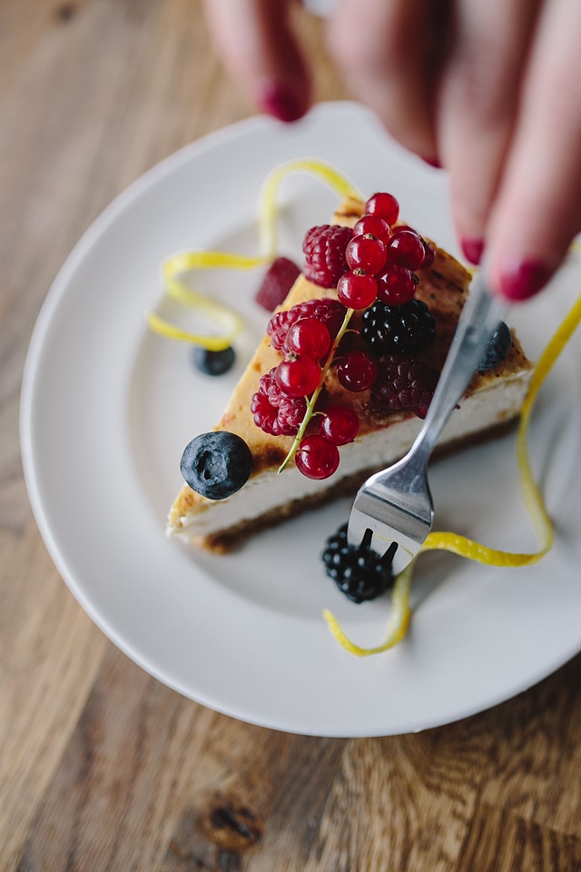 Eating cheesecake with berries