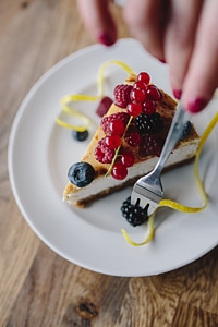 Eating cheesecake with berries