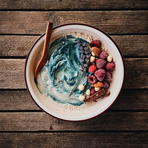 Cereals bowl with frozen raspberries and nuts photo