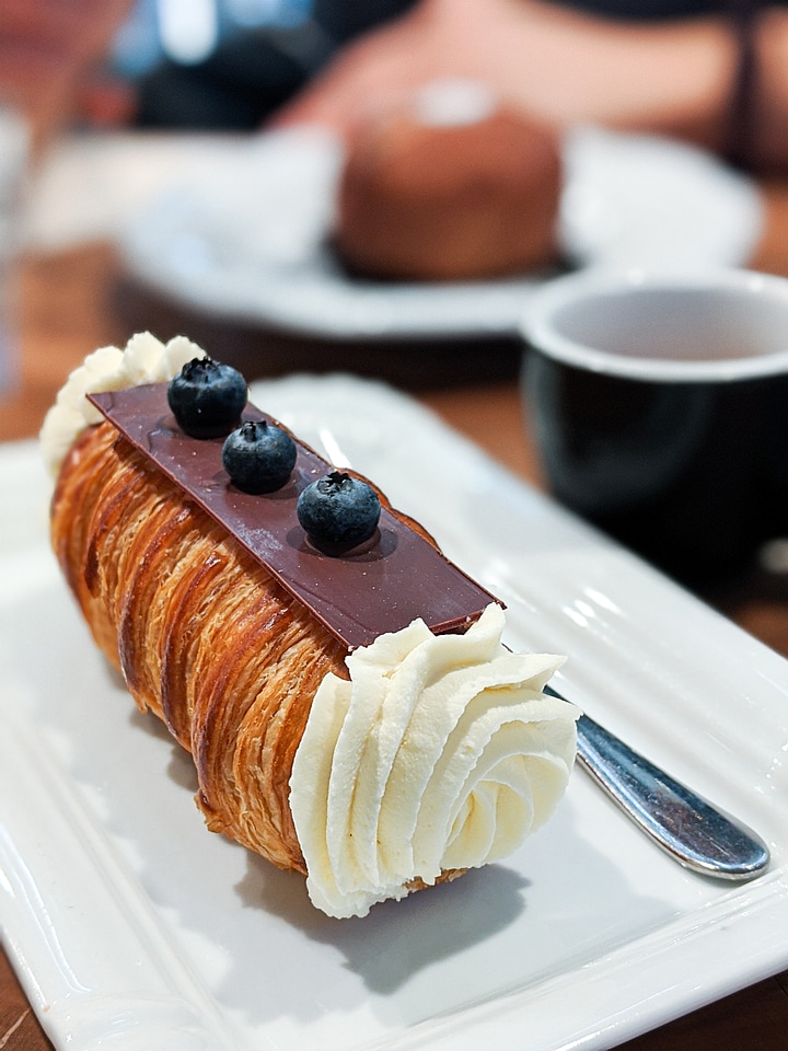 Creme roll with chocolate and blueberries on top