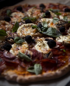 Homemade pizza with mozzarella and basil close up photo