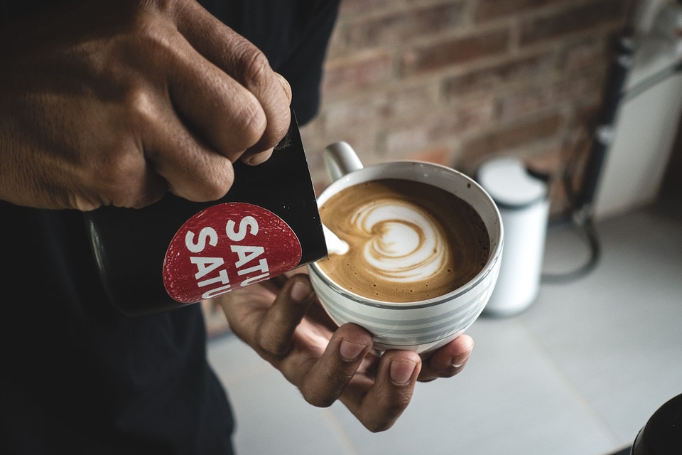 Barista making a perfect latte art on flatwhite