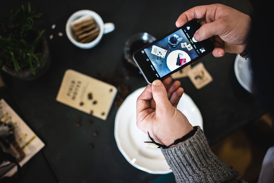 Man shooting cake with his iPhone
