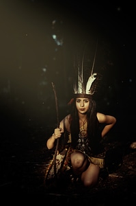 Native American Woman Wearing Plume Holding a Stick photo