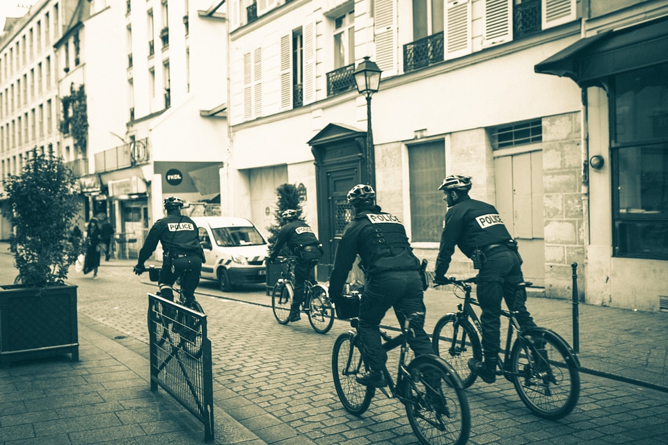 Police Patrol on Bicycles in a Small City Street photo