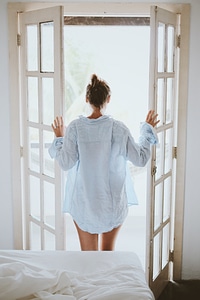 Young Woman in a Shirt Opening the Balcony Door photo