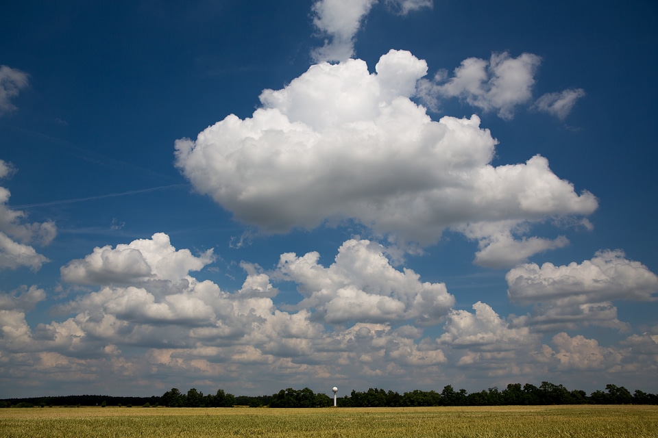 Impressive White Clouds in the Blue Sky above the Field