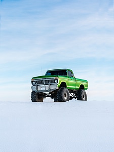 A Large Green Pickup Truck in the Snow photo