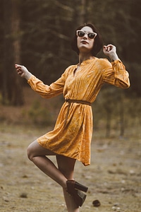 Woman in Yellow Retro Dress and High Heels Shoes Dancing in the Forest photo