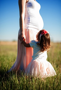 Pregnant Woman with her Baby Daughter in a Meadow photo