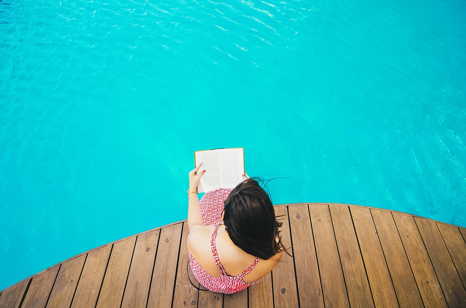 Top View of Woman Sitting on a Pier and Reading photo