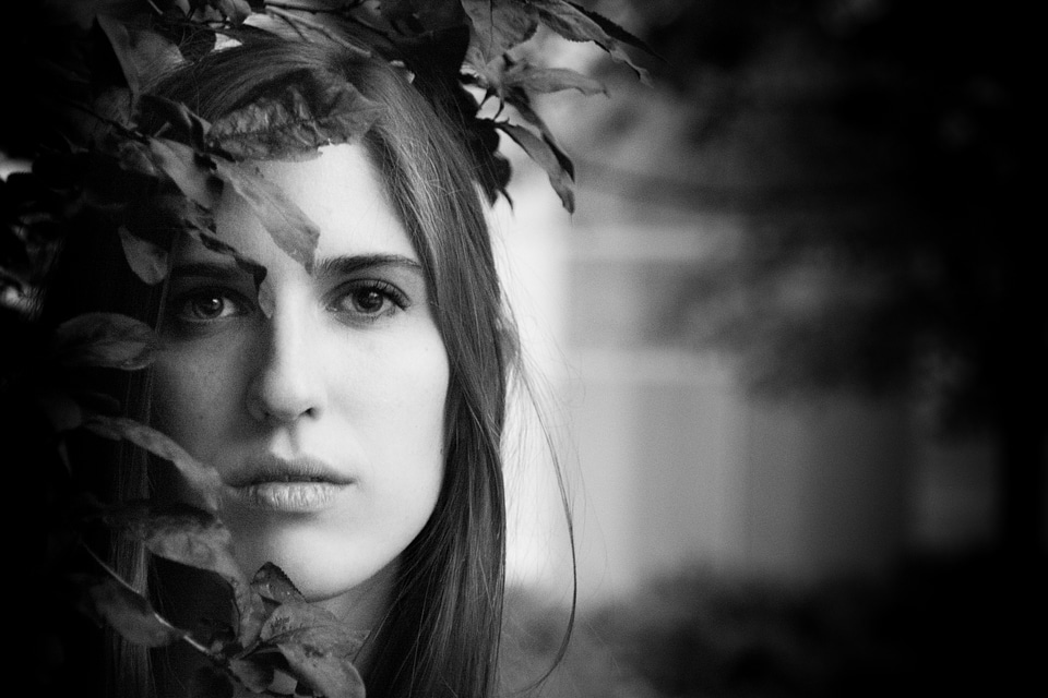 Black and White Portrait of a Beautiful Young Woman Hidden in the Leaves photo