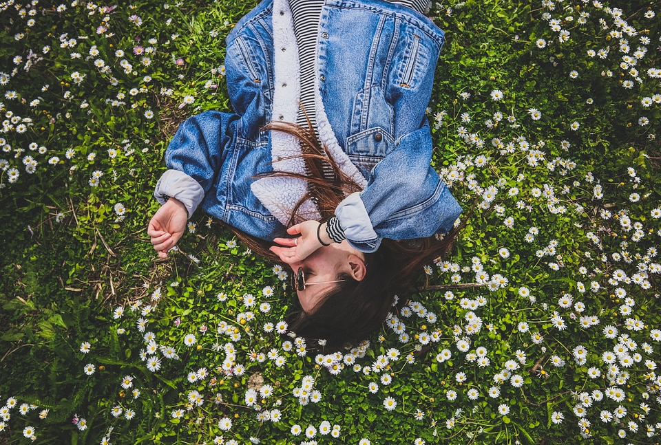 Young Brunette Enjoying Lying on the Grass full of Daisies photo