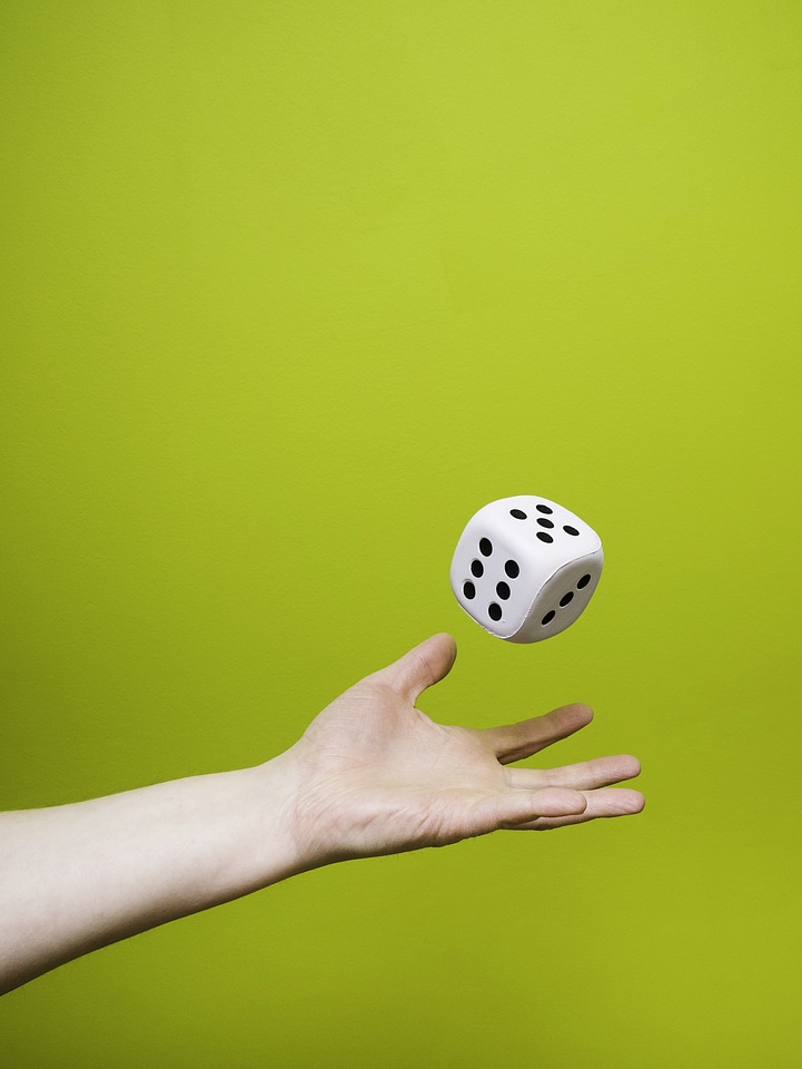 Man Throwing a Large White Dice