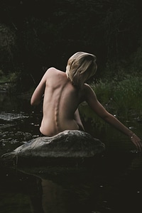 Back View of Nude Woman Sitting on the Rock photo
