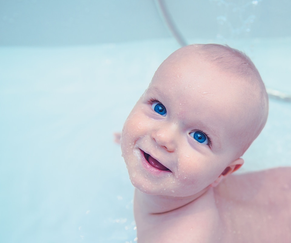 Lttle Baby Boy with Incredible Blue Eyes during the Bath