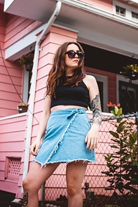 Brunette Standing in Front of Pink House photo
