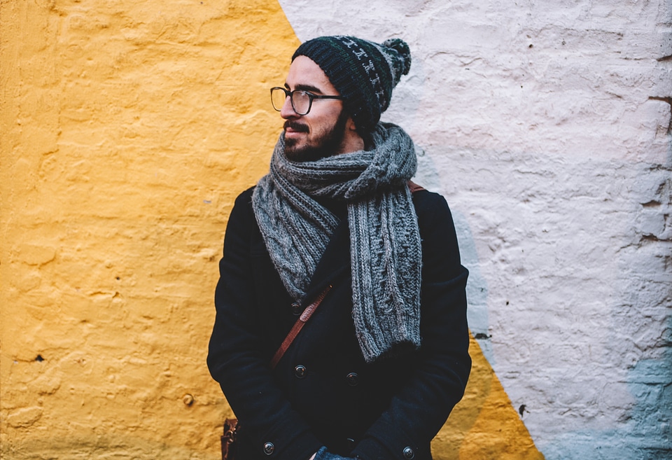 Young Male Wearing Coat, Hat and Scarf against Brick Wall photo