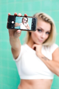 Blonde Girl Showing Selfie on Her Smartphone photo
