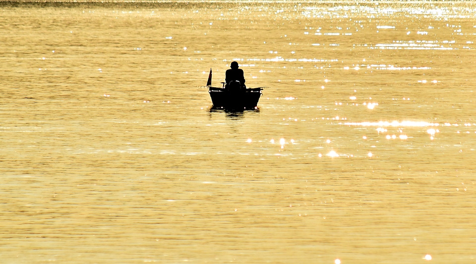 Distance fisherman fishing boat photo