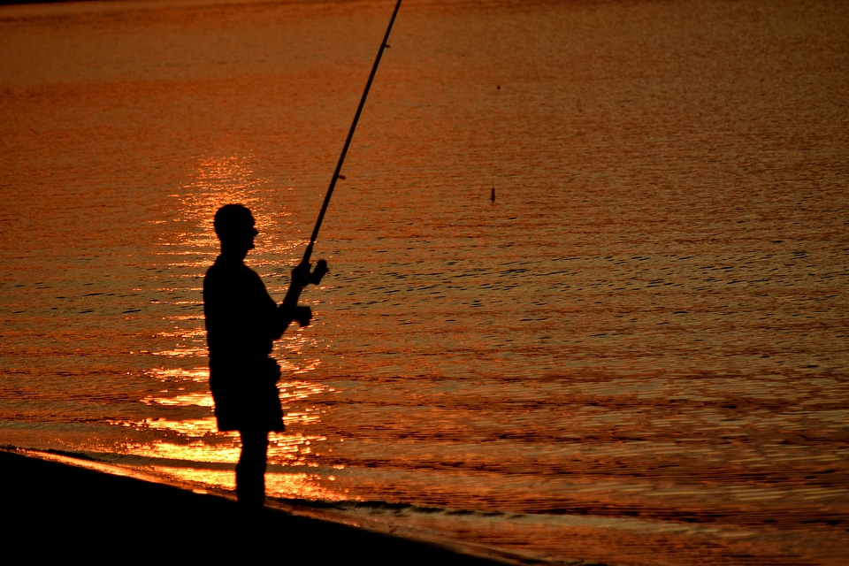 Beach sunset fisherman photo