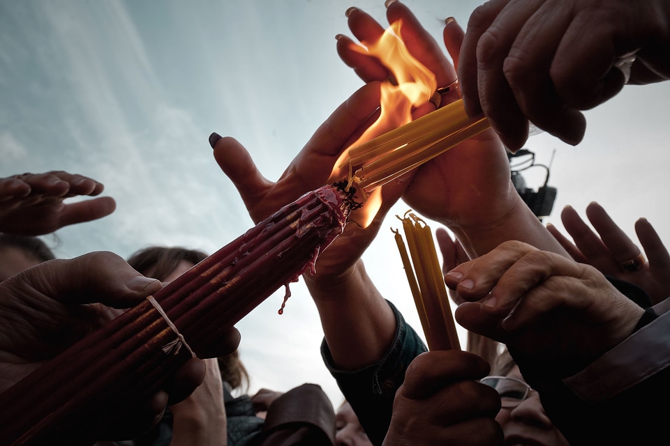Candles crowd hands