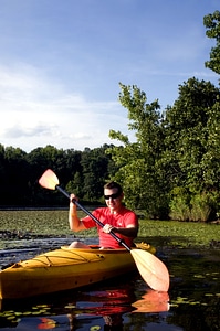 Husband kayaking lake