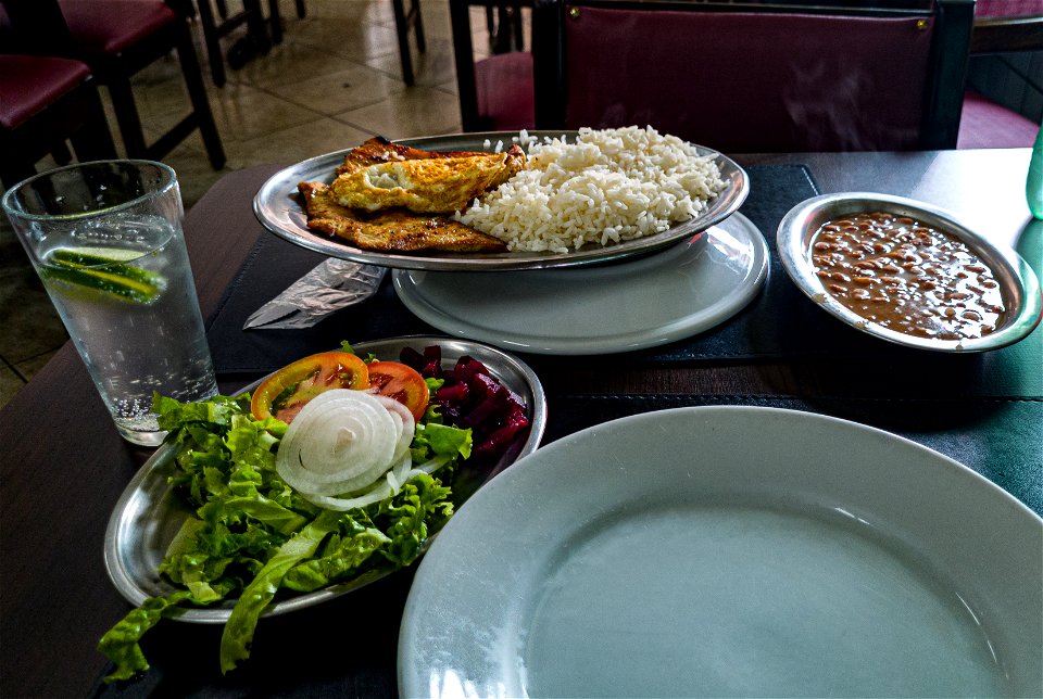 Almoço com Arroz, feijão, dois filés de frango, ovo, e uma salada.