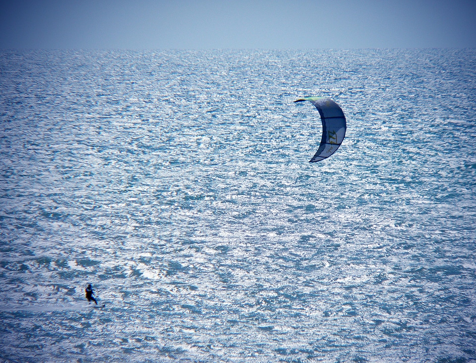 Kitesurfer in action on clear blue tropical water