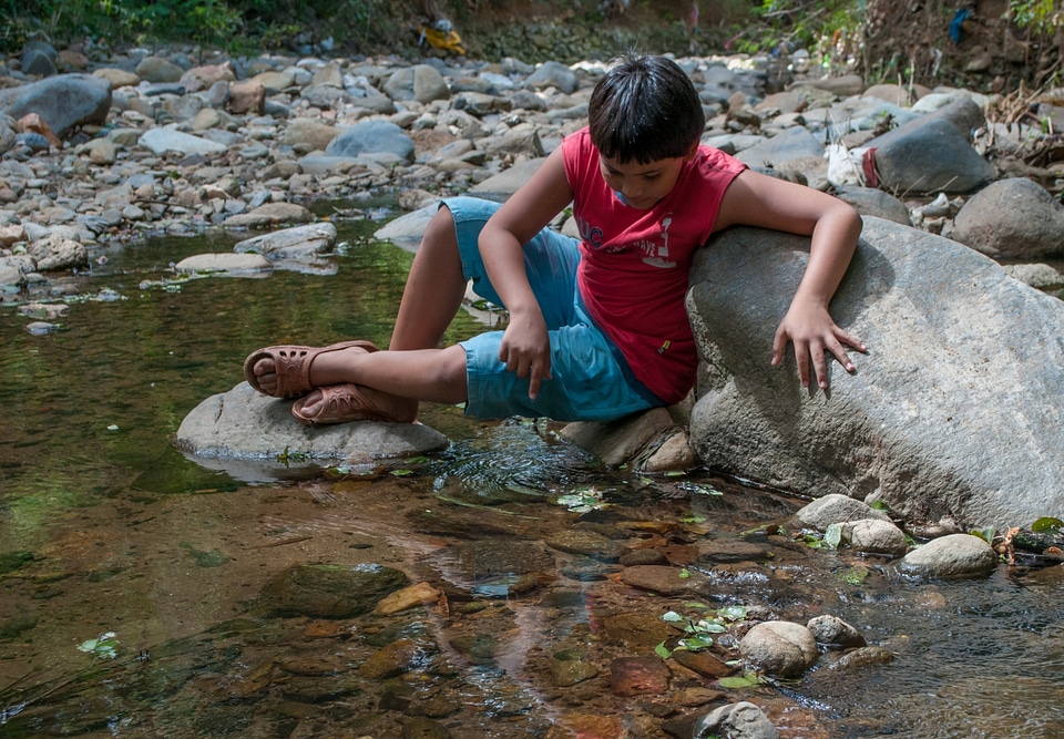 boy play with water on the river