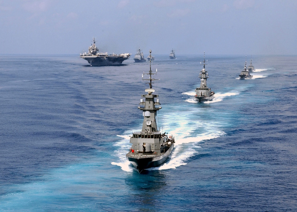 Constellation steams through the ocean with ships in its Battle