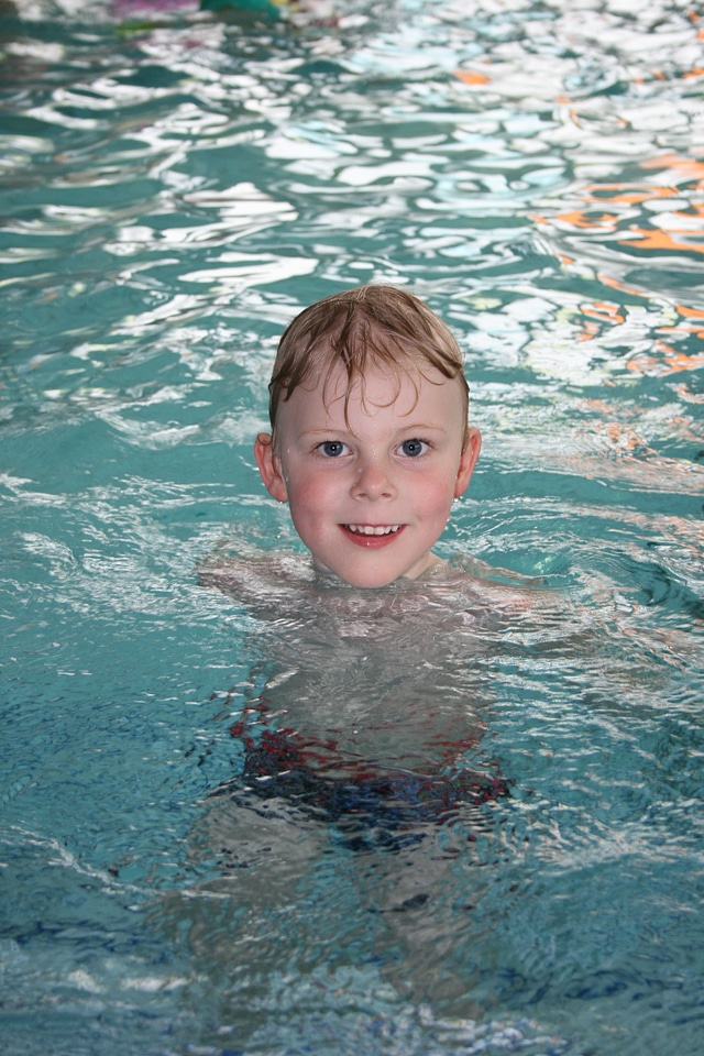 Cute boy with goggles in swimming pool photo
