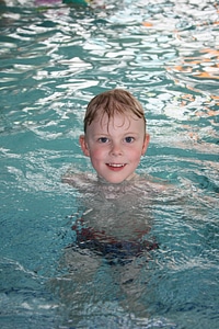 Cute boy with goggles in swimming pool photo