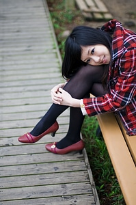 Japanese Girl Posing On A Bench photo