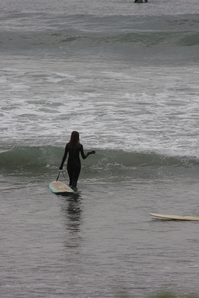 Lone Surfer carrying board along rugged Northern Oregon Coast
