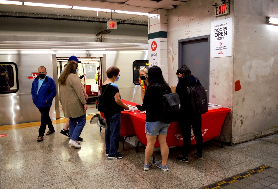 TTC Employees handing out pins and paper models.