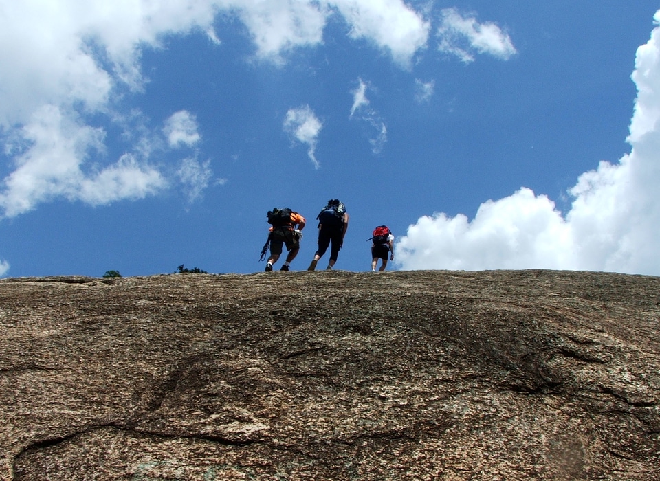 climbs a rock while trekking outdoors photo