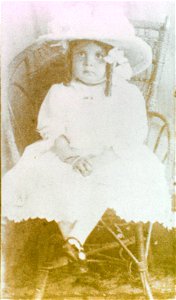 Studio portrait of a young child seated on a chair, [n.d.]