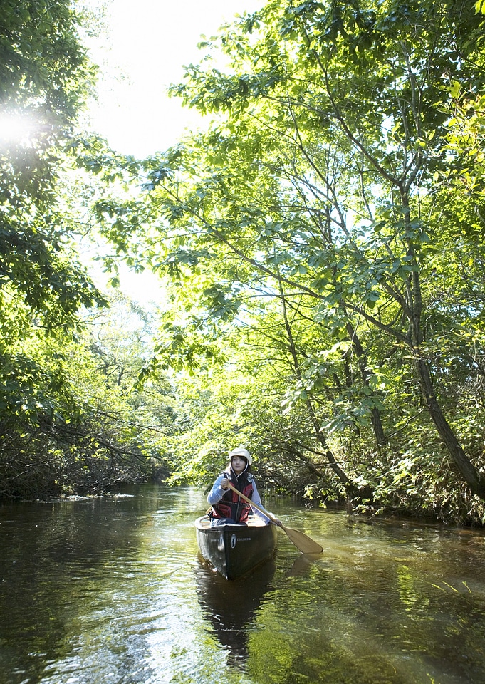 woman with kayak on forest river