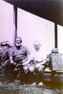 Man and boy seated on their verandah, [n.d.] photo