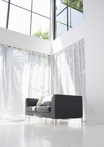 sofa with cushions below a window