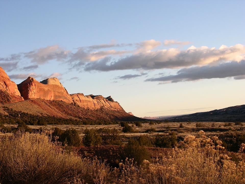 Setting sun illuminating red sandstone cliffs