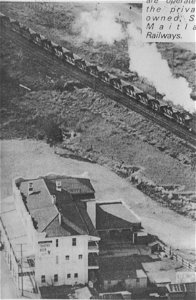 Empty coal train passing a hotel, [n.d.]