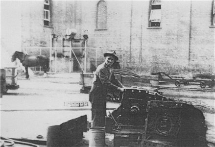 Worker in foreground, horse in background, outside a church[n.d.] photo